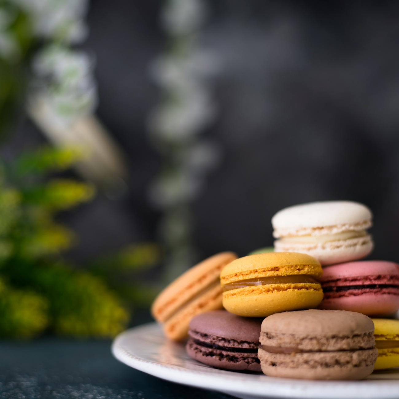 a plate of colorful macarons on a table